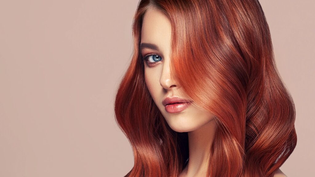 Woman with restored, glossy auburn hair after repairing over-processed hair damage