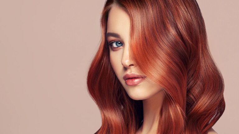Woman with restored, glossy auburn hair after repairing over-processed hair damage